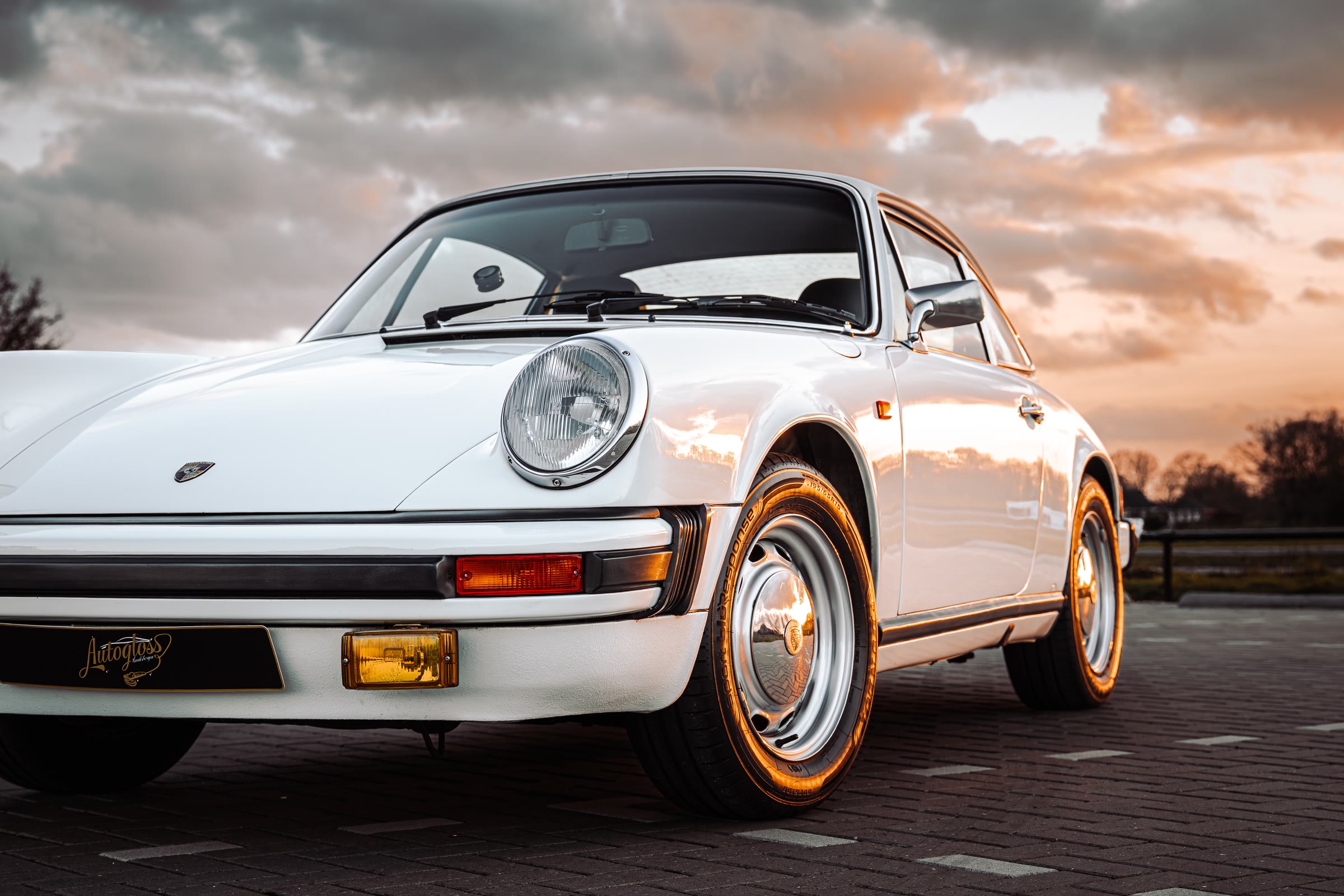 Klassieke witte Porsche 911 bij zonsondergang